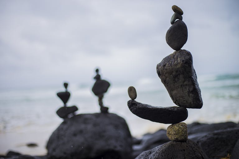 Artistic rock balancing on a serene beach in Fingal Head, NSW, Australia.